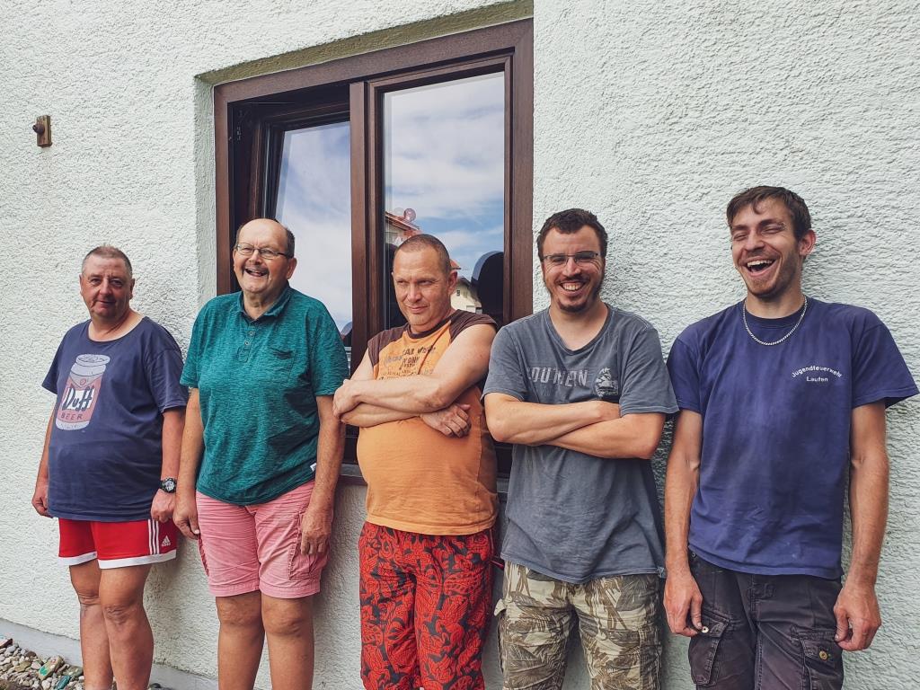 Mitarbeiter und Bewohner des Wohnhauses Freilassing sitzen auf ihrer Terrasse