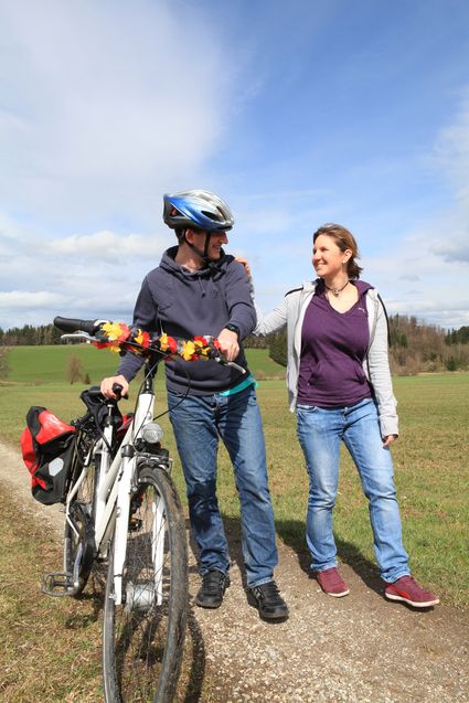 Sie sehen 2 Personen mit einem Fahrrad