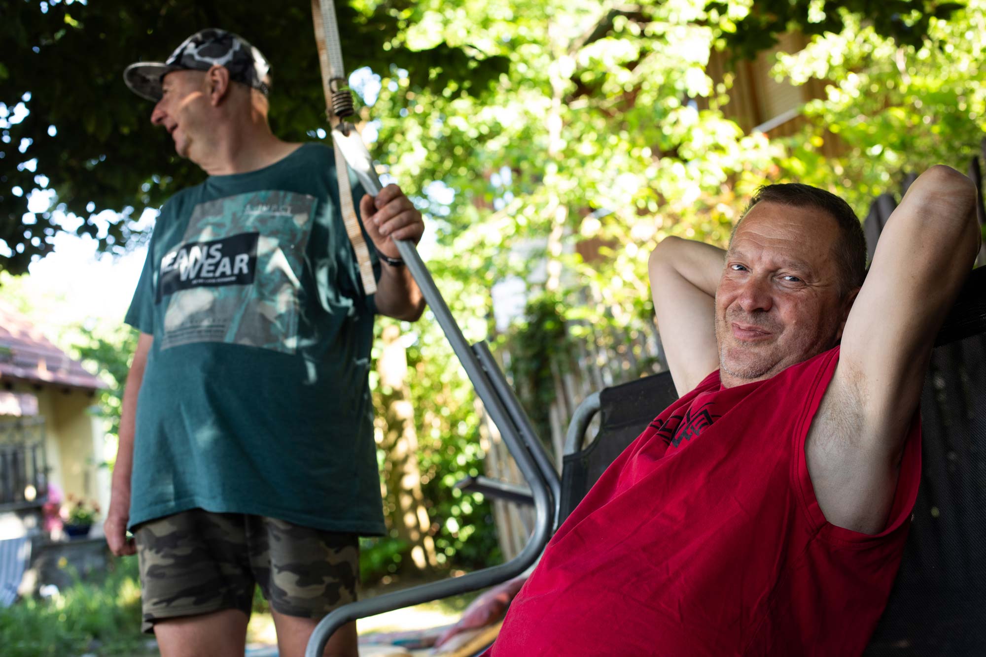 Zwei Bewohner verbringen ihre Freizeit im Garten. Einer der beiden sitzt in einer Hollywood-Schaukel.