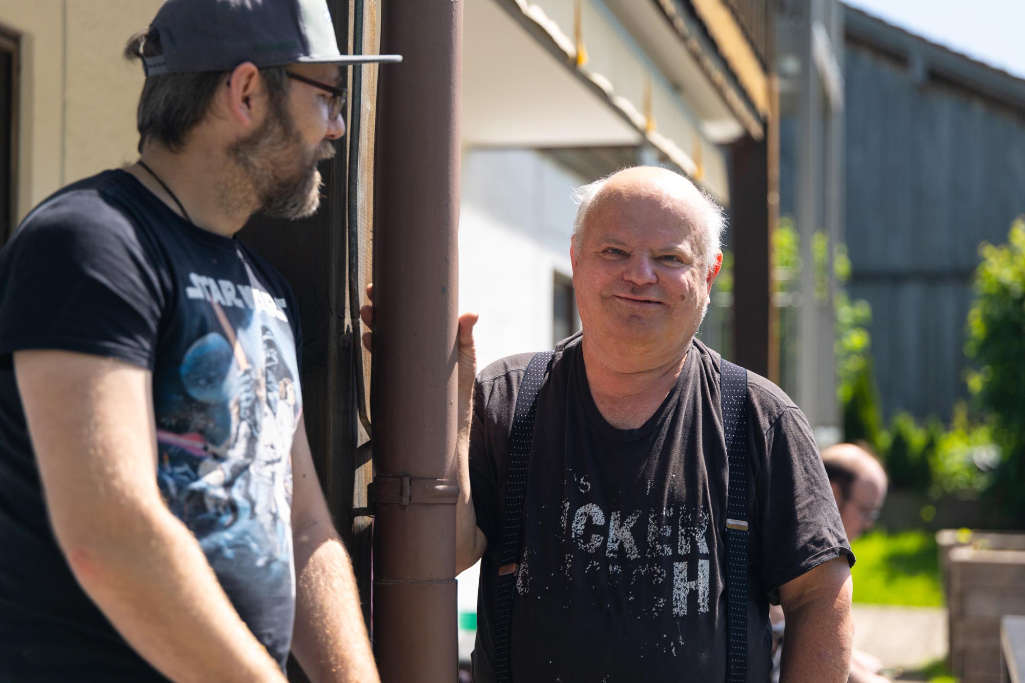 Ein Mitaerbeiter und ein Bewohner unterhalten sich auf der Terrasse.